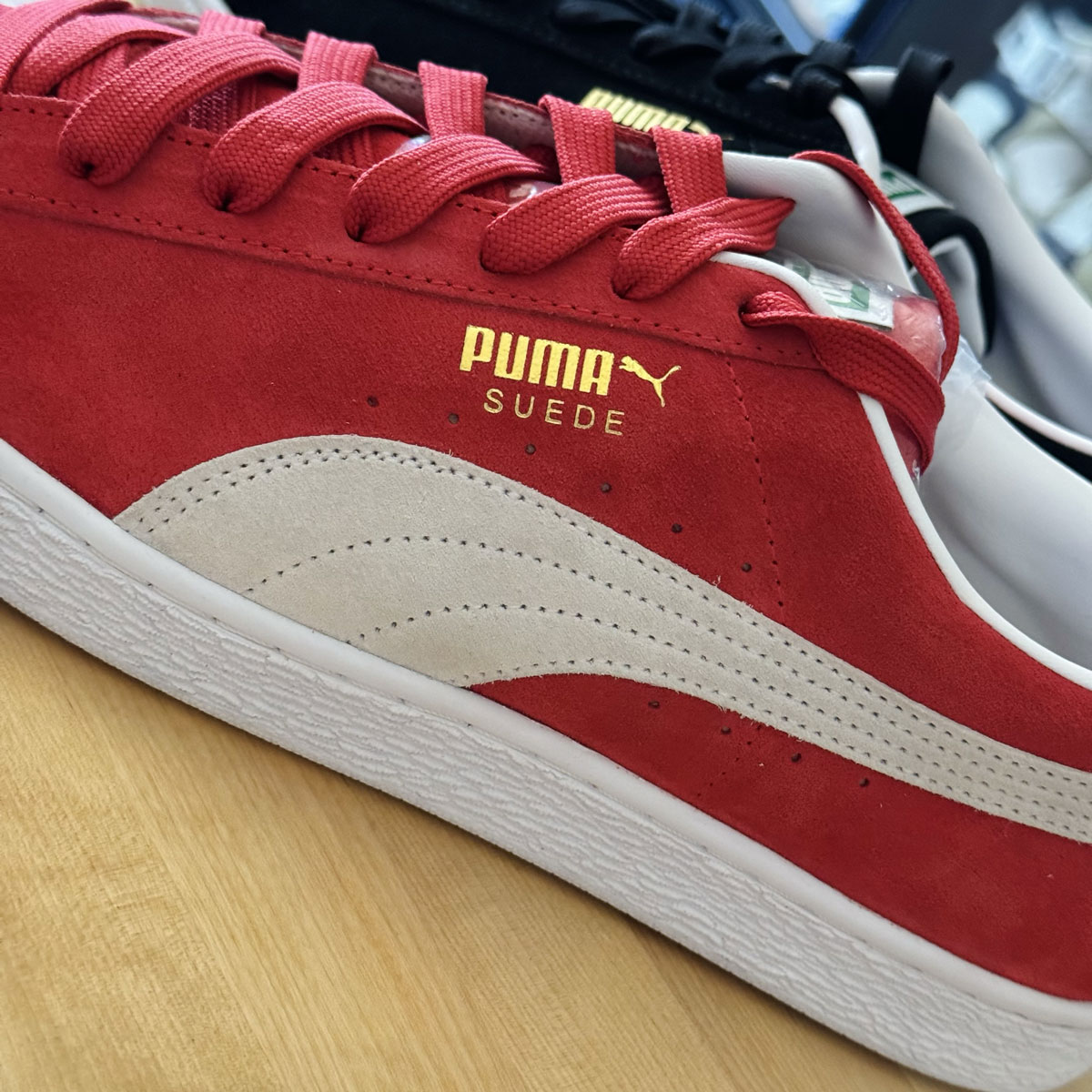 A pair of red and black PUMA Suede sneakers